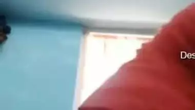 Smiling Indian with glasses listens to music and undresses at once
